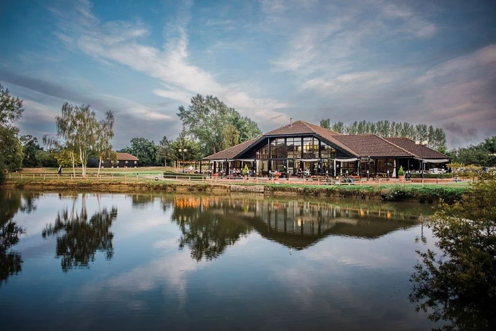 building with wooden roof in front of lake